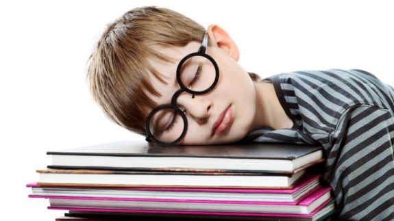 Educational theme: boy teenager sleeping on his books. Isolated over white background.