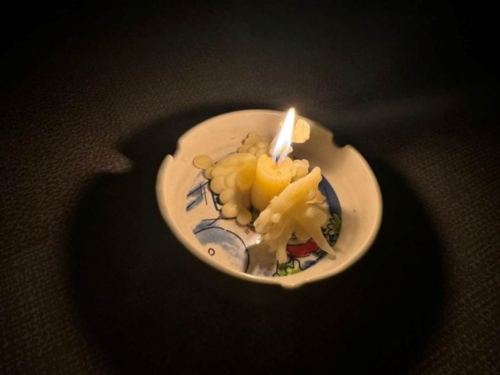 A lit candle in a bowlDescription automatically generated
